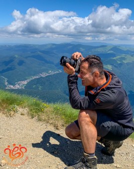 38 Un ghid montan care ține un aparat foto în mână și face poze pe munte